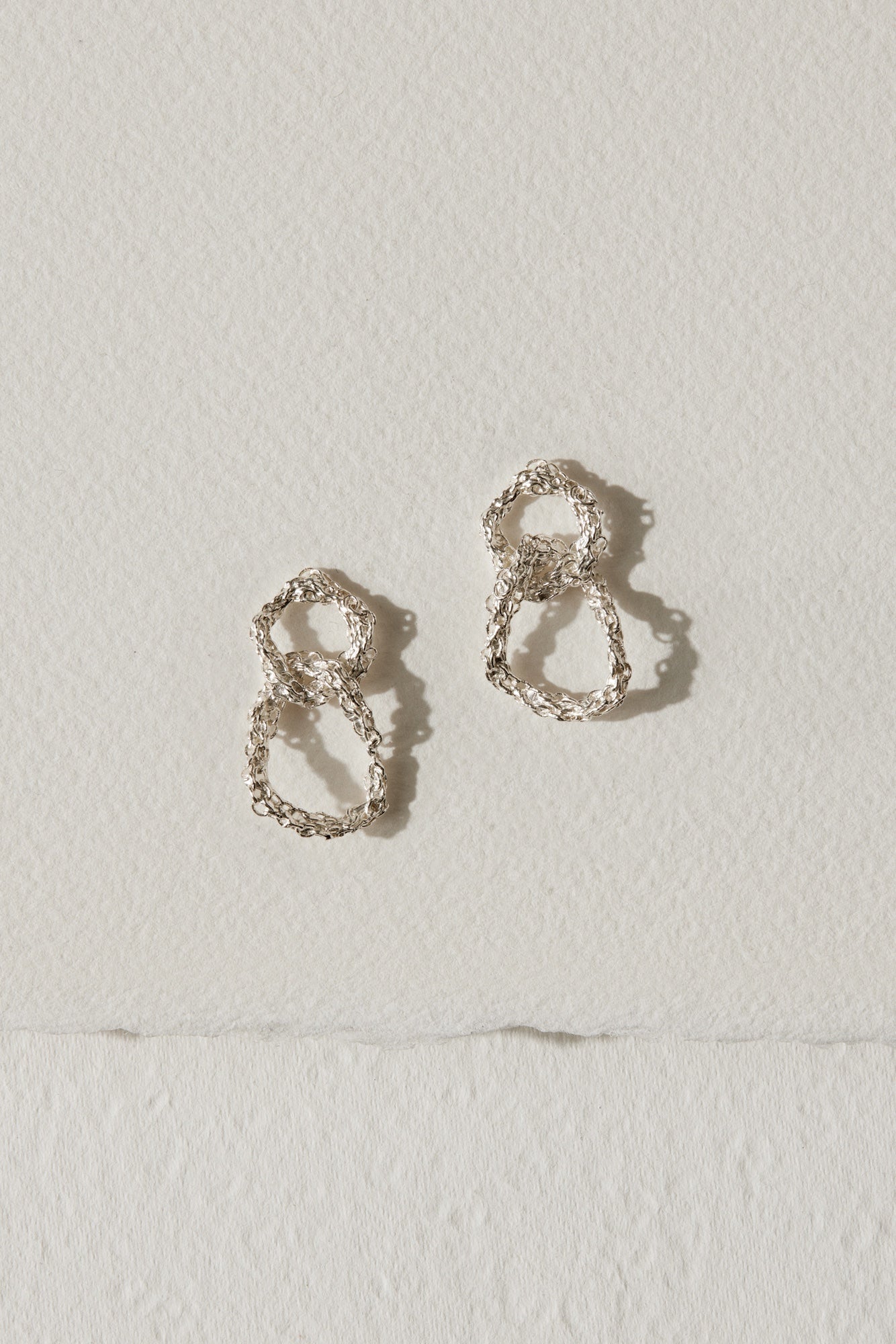 Intertwined medium drop earrings close up