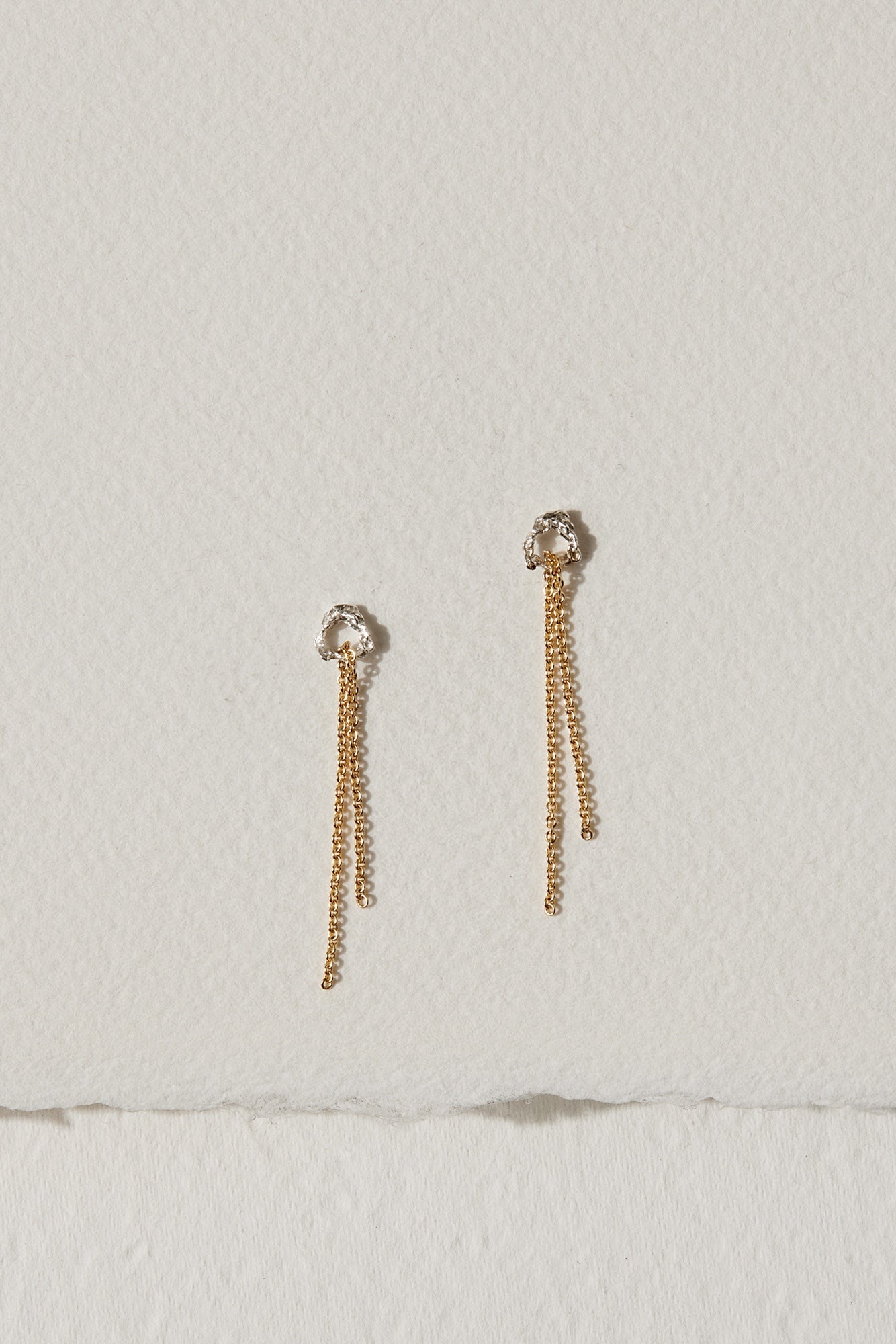 Silver and 10k gold drop earrings featuring a fine chain with a subtle, grainy texture.
