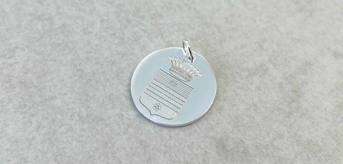 Silver pendant with intricate design on a light gray background